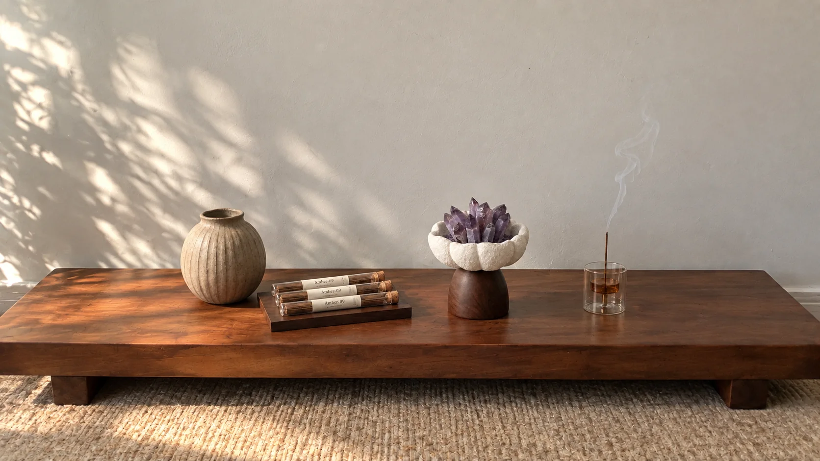 Amethyst crystal and incense arranged on a sunlit wooden table
